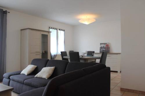 un salon avec un canapé bleu et une table dans l'établissement Mais 3 pièces AYTRE - LR000-029, à Aytré