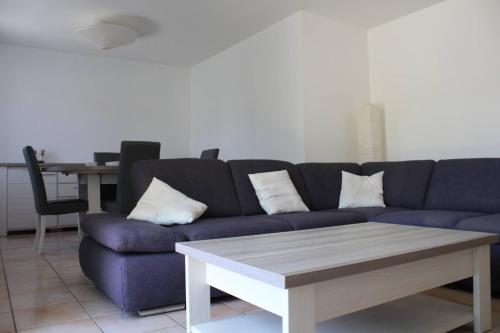 un salon avec un canapé bleu et une table dans l'établissement Mais 3 pièces AYTRE - LR000-029, à Aytré