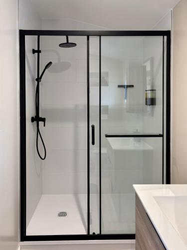 une douche avec une porte vitrée dans une salle de bain dans l'établissement Villa Moussarde, à Mouxy