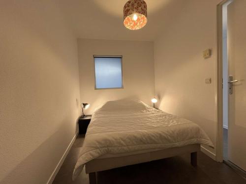 - une petite chambre avec un lit et une lumière dans l'établissement Appt 1 pièce bis LA ROCHELLE - LR050-A116B, à La Rochelle