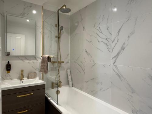 a white bathroom with a tub and a sink at In the heart of the Town centre Ringwood, New Forest - Star Cottage in Ringwood