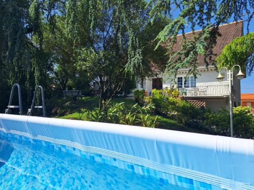 a swimming pool in front of a house at Lé Luquentia, demeure de charme, piscine, grand jardin, spa, billard in Gujan-Mestras