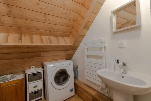 une salle de bain avec une machine à laver et un lavabo dans l'établissement Maison authentique en granit - Chaumeil - Cheminée, à Chaumeil