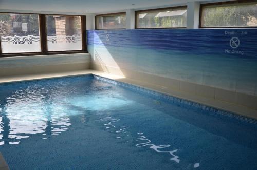 une piscine dans un immeuble avec le soleil qui brille à travers les fenêtres dans l'établissement Fantastic Holiday Home 5 ensuite bedrooms Pool No Pets, à Désertines