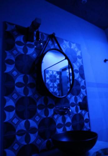 a bathroom with a mirror and a blue light at La Dimora del Principe-Piano terra in Trani