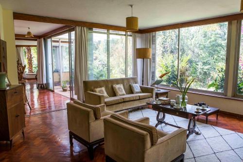 a living room with a couch and a table at Beautiful Historic House by YourHost Nairobi in Nairobi