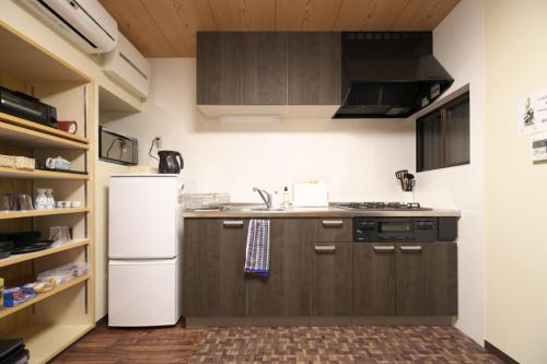 a kitchen with brown cabinets and a white refrigerator at 楽宿 -強羅- 031h in Hakone