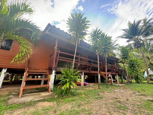 a house with palm trees in front of it at Libong Beach Resort in Ko Libong