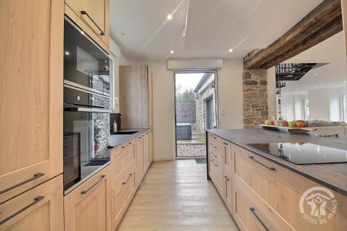 a large kitchen with wooden cabinets and a counter top at La maison de oueval in Frehel