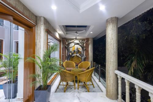 a balcony with a table and chairs and plants at Hotel Pravasa Stay in Vadodara