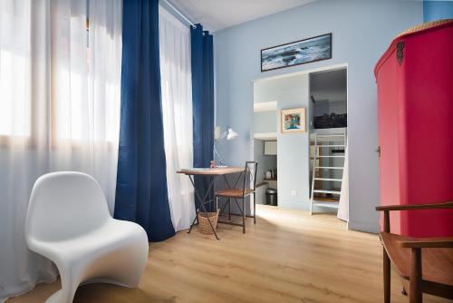 - un salon avec une chaise blanche et une table dans l'établissement Loft avec extérieur - Proche Paris & Transport, à Montreuil