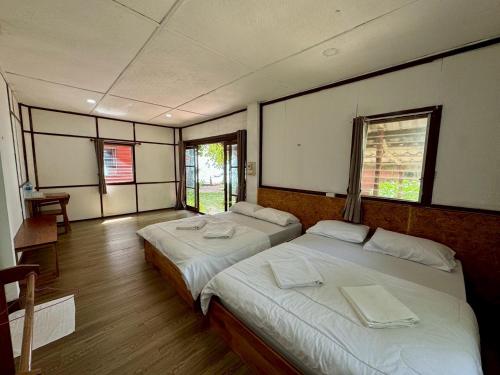 two beds in a room with two windows at Libong Beach Resort in Ko Libong