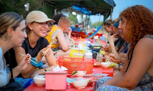 a group of people sitting at a table eating food at Lub d Siem Reap - Near Pub Street & Angkor Wat in Siem Reap