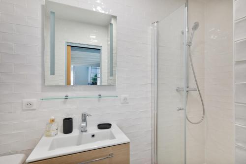 une salle de bain blanche avec un lavabo et une douche dans l'établissement Loft avec extérieur - Proche Paris & Transport, à Montreuil