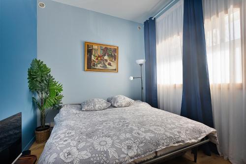 - une chambre avec des murs bleus et un lit avec des oreillers dans l'établissement Loft avec extérieur - Proche Paris & Transport, à Montreuil