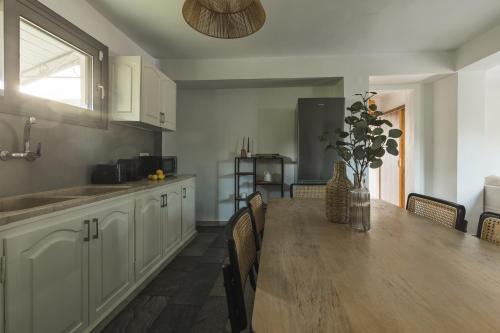 a kitchen with a long wooden table and chairs at Binios Villa - private pool, walking distance from the Beach in Vasilikos