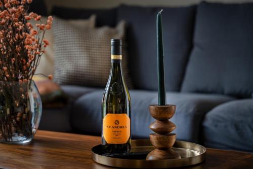 a bottle of wine and a vase on a table at Ház a Hold utcában in Kehidakustány