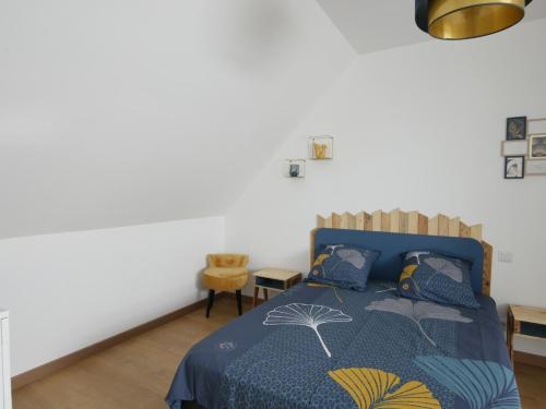 une chambre avec un lit avec une couette bleue dans l'établissement LE CHAMP MICHEL - appartement lumineux et cosy, à Chevaigné