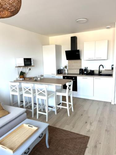 une cuisine et un salon avec une table et des chaises dans l'établissement Appartement Le Riva B304, à Barneville-Carteret