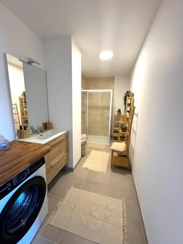 une salle de bain avec une machine à laver et un lavabo dans l'établissement Appartement Le Riva B304, à Barneville-Carteret
