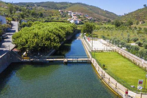 a river with a bridge in the middle at Casinha da Deolinda in Aldeia das Dez