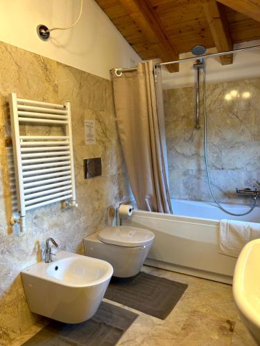 a bathroom with two sinks and a tub and a toilet at Casa Bianca Vicino Humanitas e Forum di Assago in Rozzano