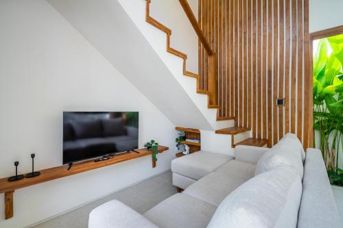 a living room with a white couch and a flat screen tv at Kuta Beach Villas by Great Bali Villas in Badung