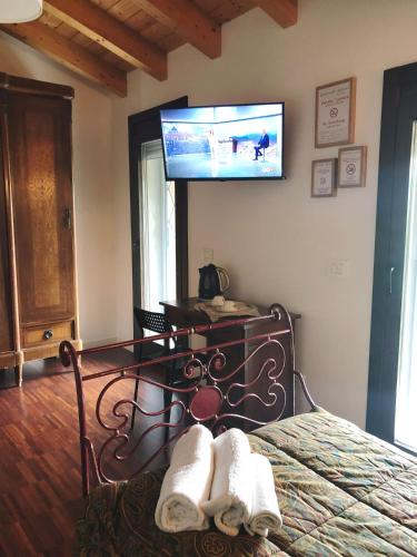 a bedroom with a bed and a tv on the wall at Casa Bianca Vicino Humanitas e Forum di Assago in Rozzano