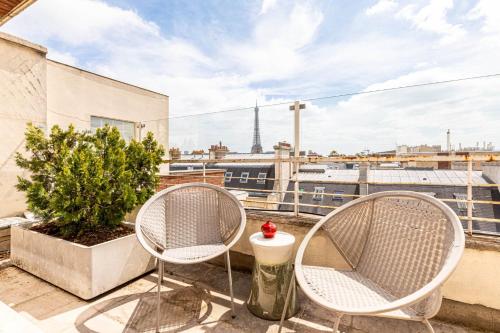 deux chaises sur un balcon avec vue sur la tour Eiffel dans l'établissement GuestReady - Parisian Charm with Eiffel Tower View, à Paris