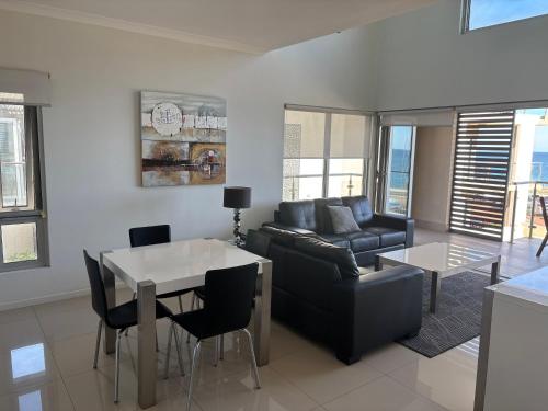 a living room with a couch and a table at Bunbury Seaview Apartments in Bunbury