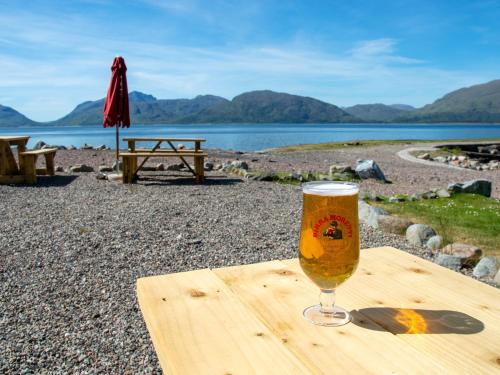 a glass of beer sitting on a wooden table at Holly Tree Hotel, Swimming Pool & Hot Tub in Glencoe