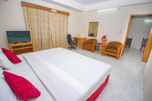 a bedroom with a bed and a desk and a television at Laurel Hotel Lake View in Dhaka