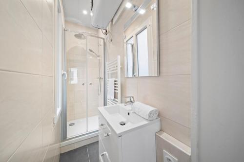 une salle de bain blanche avec un lavabo et une douche dans l'établissement Confort & Calme - Appartement Centre Historique - Tout équipé, à Dijon