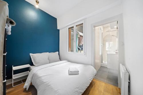 Cette petite chambre comprend un lit avec un mur bleu. dans l'établissement Confort & Calme - Appartement Centre Historique - Tout équipé, à Dijon