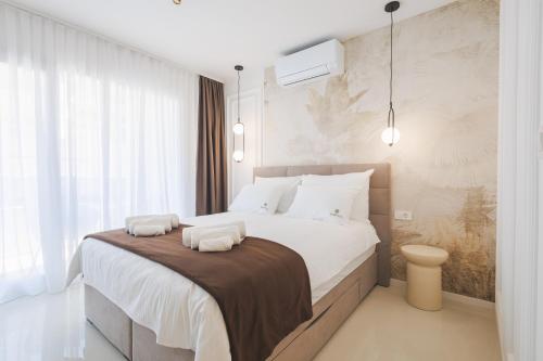 a bedroom with a large bed with two towels on it at Apartments Maritea in Vodice