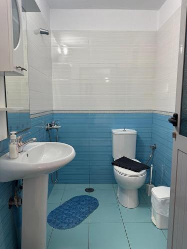 a blue and white bathroom with a toilet and a sink at Emy's Rooms in Himare
