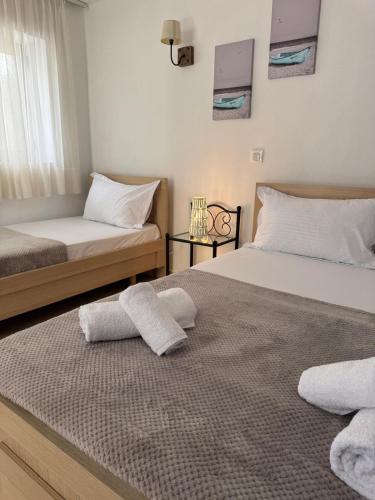 a bedroom with two beds with towels on top of it at Emy's Rooms in Himare
