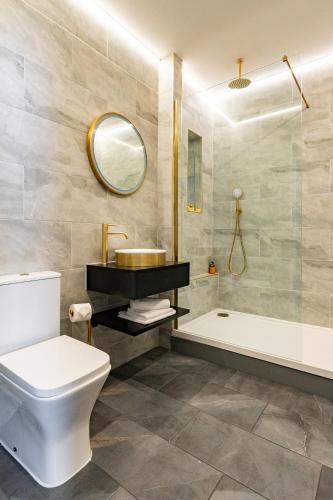 a bathroom with a toilet and a sink and a tub at Above Hotels in Burnley