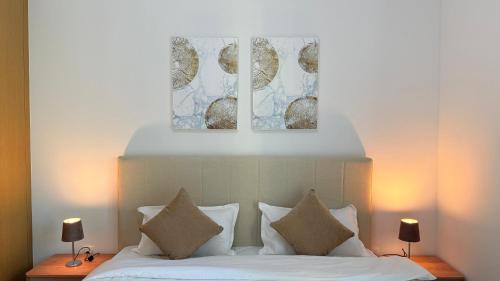 a bedroom with a bed with two pictures above it at Premium 2 Bedroom Creek Horizon in Dubai
