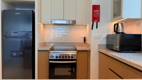 a kitchen with a refrigerator and a stove and a microwave at Premium 2 Bedroom Creek Horizon in Dubai