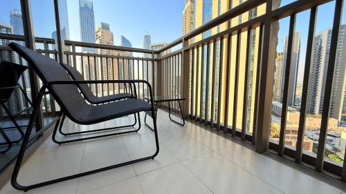 a chair on a balcony with a view of a city at Premium 2 Bedroom Creek Horizon in Dubai