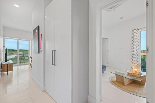 a hallway with white walls and a door with a table at Arubas Life 200 in Noord