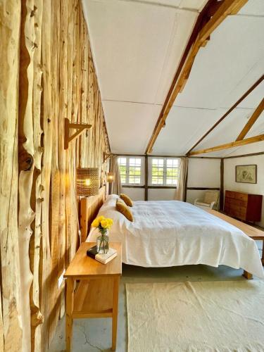a bedroom with a large bed and a wooden wall at The Barn by YourHost Nanyuki Kenya in Nanyuki