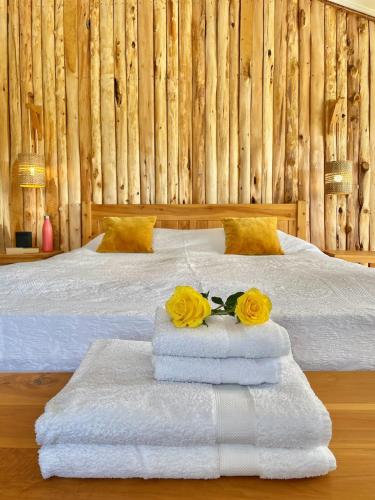 a bed with two towels and two roses on it at The Barn by YourHost Nanyuki Kenya in Nanyuki
