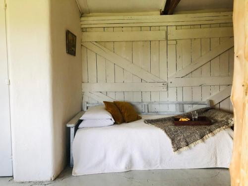 a bedroom with a white bed with a wooden door at The Barn by YourHost Nanyuki Kenya in Nanyuki