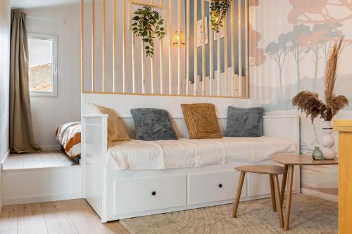 une chambre d'enfant avec un lit blanc et une table dans l'établissement Petit cocon provençal à 2mn d'Arles, à Fourques