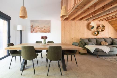 une salle à manger avec une table et un canapé dans l'établissement Maison du Canal au bord du canal à Cazaux, à La Teste-de-Buch