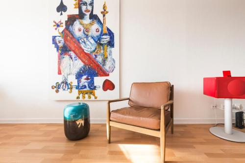 un salon avec une chaise et un tableau dans l'établissement Design et calme au bord de l'eau, à Mulhouse