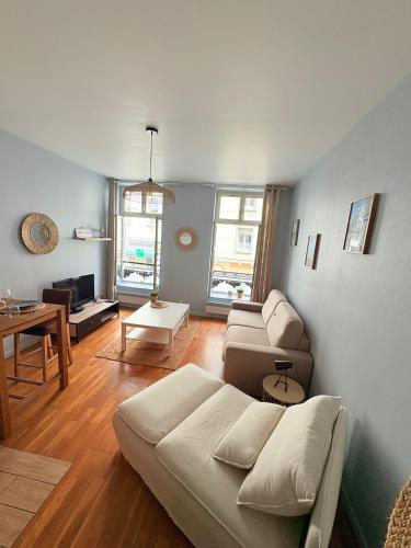 un salon avec un canapé et une table dans l'établissement La Cabine 17 - Studio de Standing au coeur du Centre-Ville, à Boulogne-sur-Mer