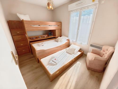 une petite chambre avec deux lits et une chaise dans l'établissement Le Jardin de Blonville - À 10 min à pied de la plage - tennis & équitation à côté, à Blonville-sur-Mer